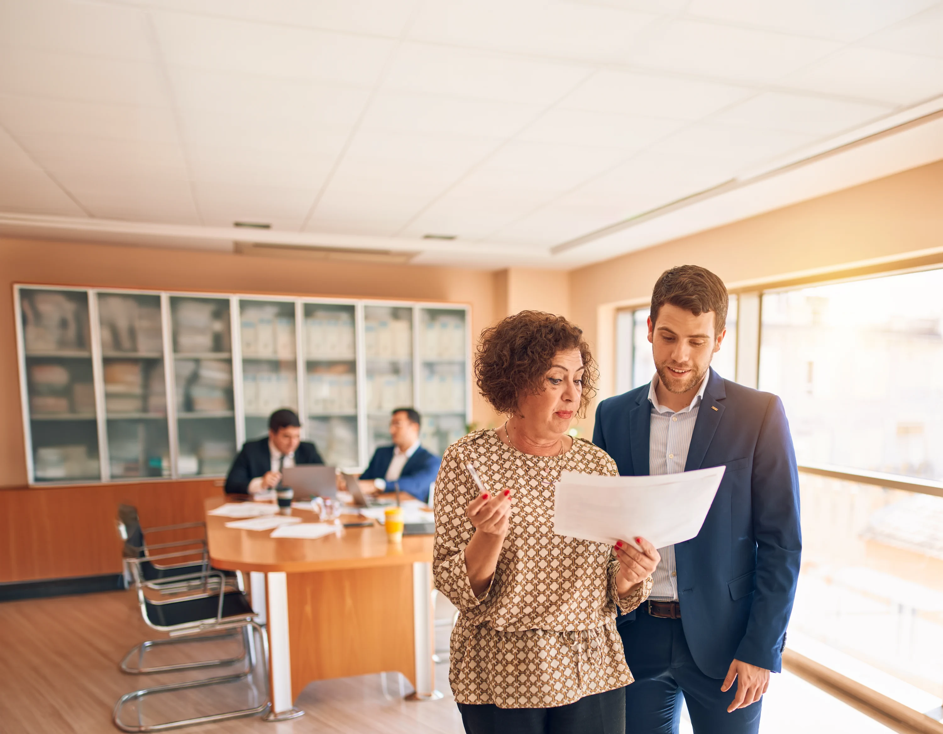 Duas pessoas conversando em um escritório.